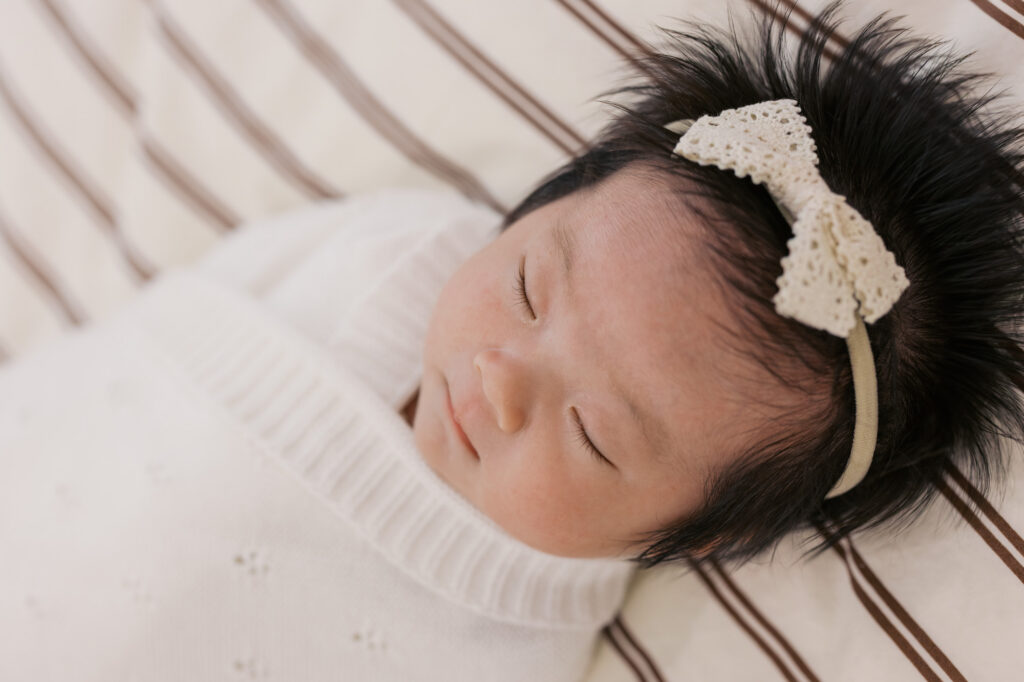 close up of one month old newborn baby laying asleep on a bed during newborn photography session in Santa Clara