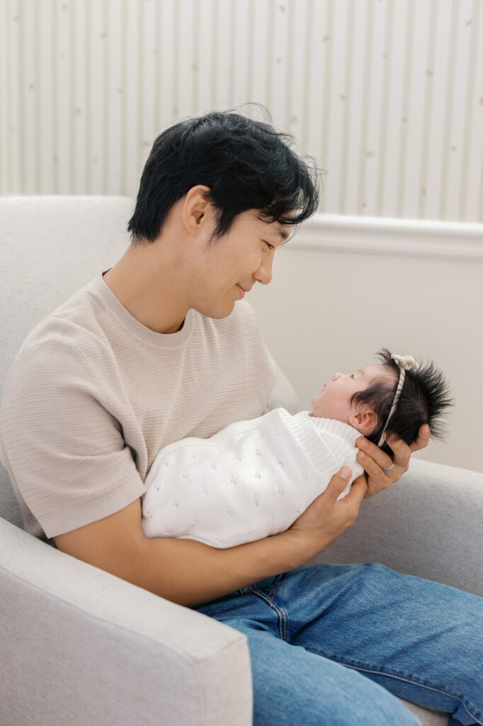 new dad gazes down at one month old baby girl during Santa Clara newborn photography session